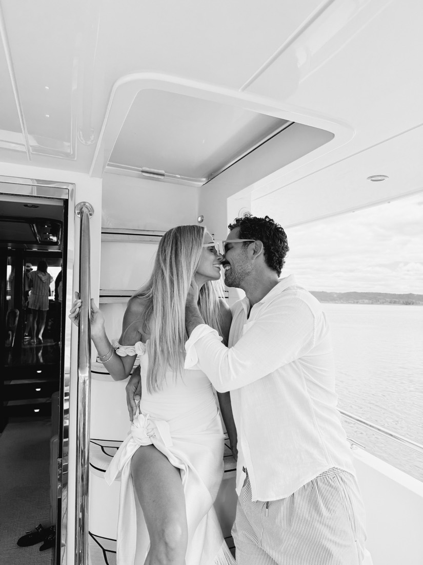 Katie and Danny kissing on the boat, in black and white
