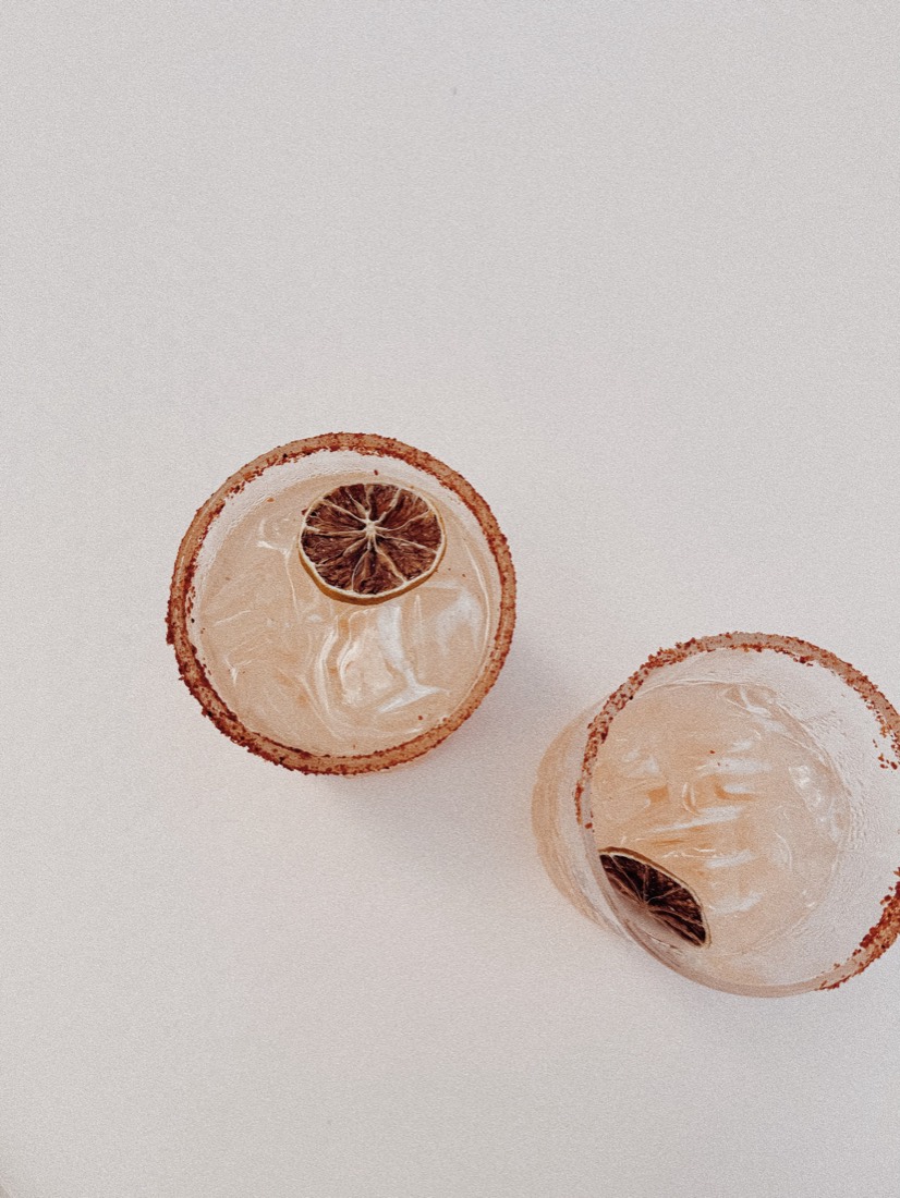 Two cocktails with sugared rims and dried citrus, seen from above