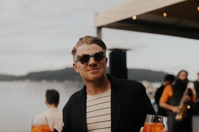 A guest enjoying a drink by the water