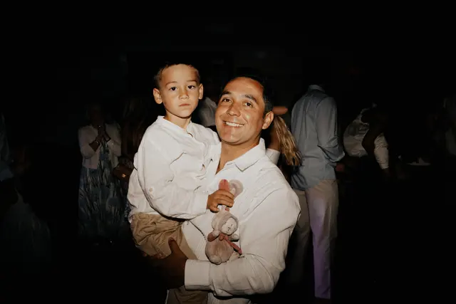 A guest holding a child at the after party