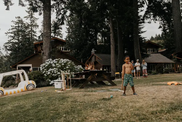 A guest playing cornhole on the lawn