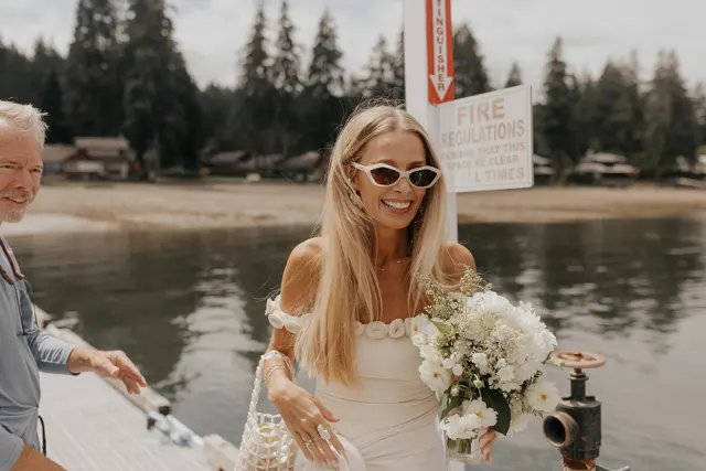 Katie in sunglasses carrying her wedding bouquet
