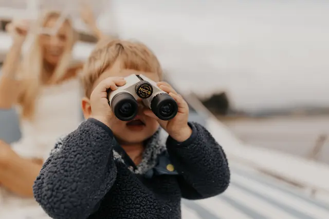 A child looking through binoculars