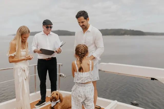 Katie and Danny with their officiant on the aft deck
