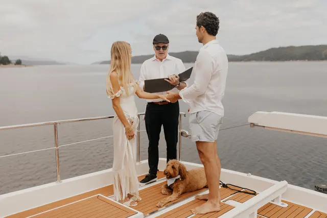 Katie and Danny with their officiant on the aft deck