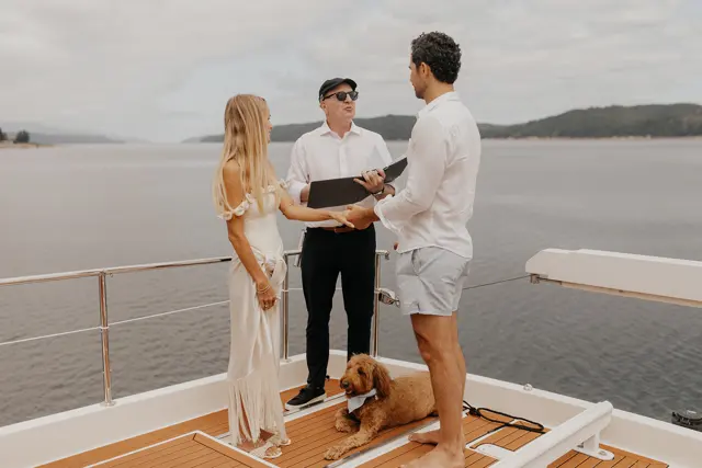 Katie and Danny with their officiant on the aft deck