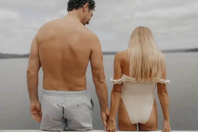 Katie and Danny holding hands at the back of the boat